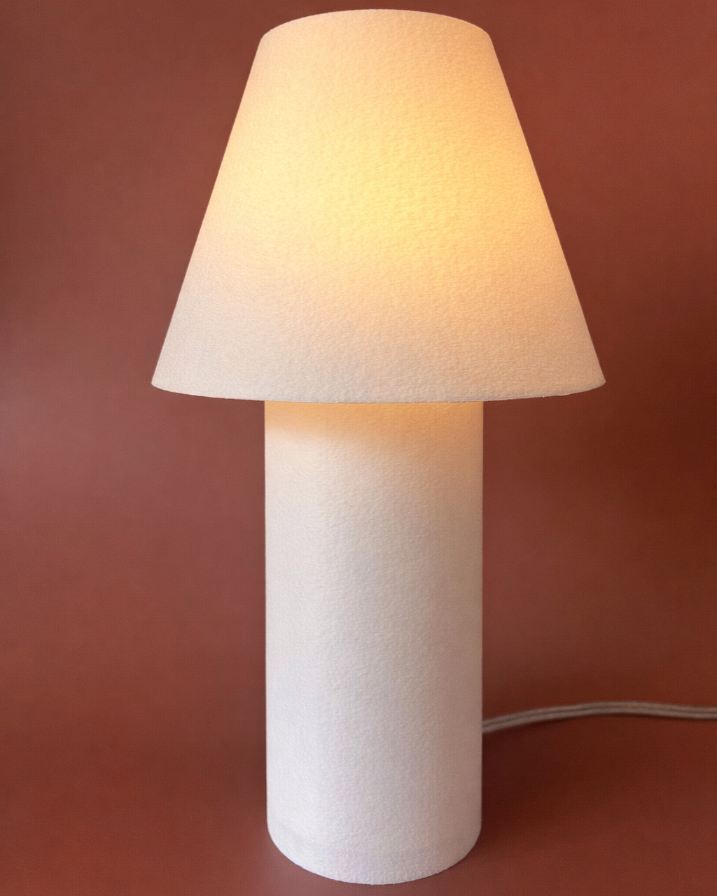 White table lamp with a beige shade on a brown background